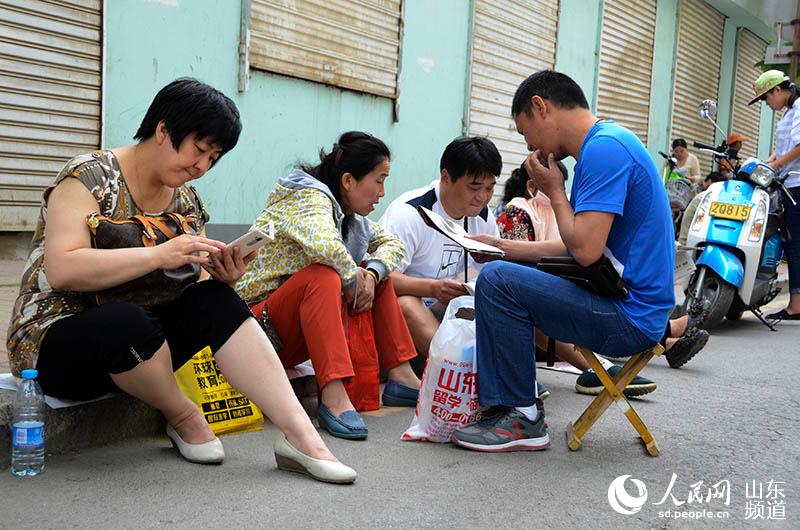 高考首日 山东一名高一学生探访考场外候考家