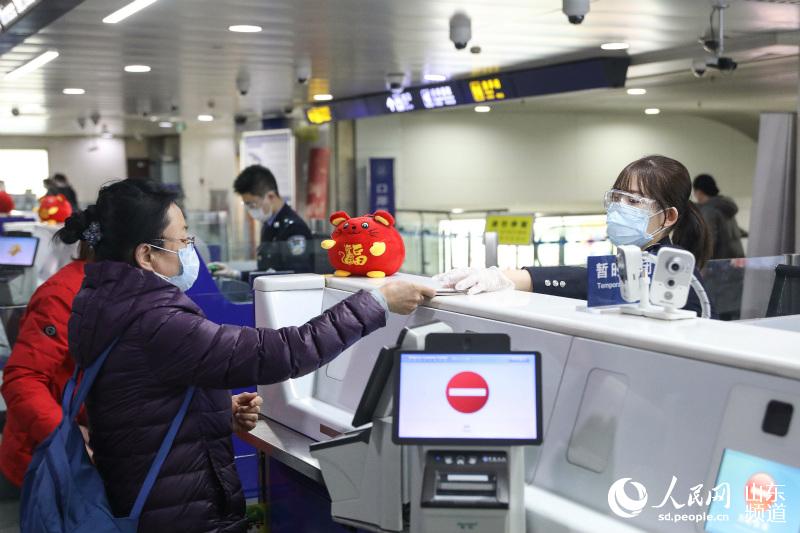1月28日，青島機場出入境邊防檢查站民警為旅客辦理通關手續。（攝影 解豪）