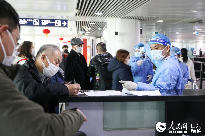 1月28日，青島流亭機場海關關員指導旅客填寫健康申明卡。（攝影 解豪）