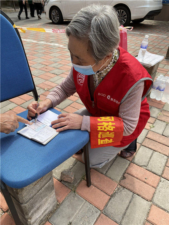 重慶南路48號檢測點，銀發志願者幫居民把信息提前寫到紙條上，方便登記人員登記。
