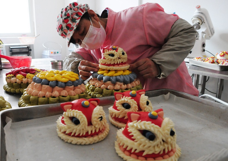 面點師在制作“醒獅發財”五彩花糕。張振祥攝