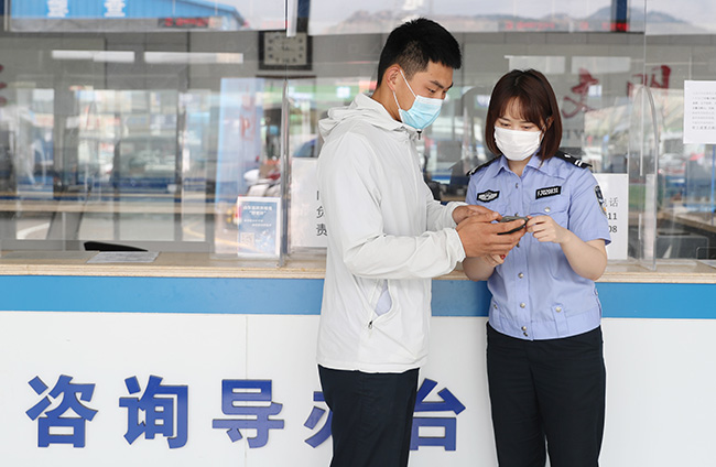 9月1日，青岛市公安局青岛经济技术开发区分局交通警察大队车辆管理所的工作人员在给驾驶员讲解如何网上申领电子驾驶证。（张进刚 摄）