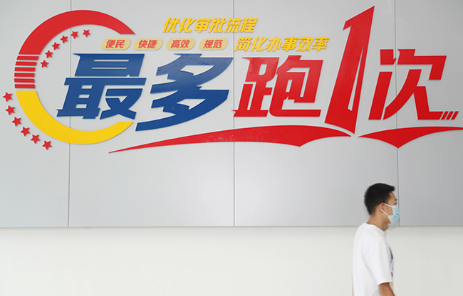 9月1日，在青岛市公安局青岛经济技术开发区分局交通警察大队车辆管理所，一驾驶员去窗口办理电子驾驶证。（张进刚 摄）