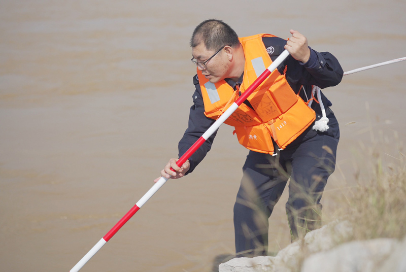 10月8日，一名水政職工在汛期承擔探摸工作，圖為他正在探摸根石是否走失。 郭冬陽攝