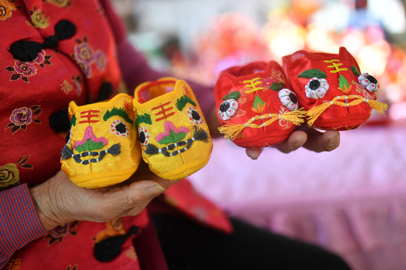 2022年1月，在山東省青島市城陽區河套街道，民間手藝人趙建美展示手工制作的民間傳統“虎頭鞋”。 王海濱攝