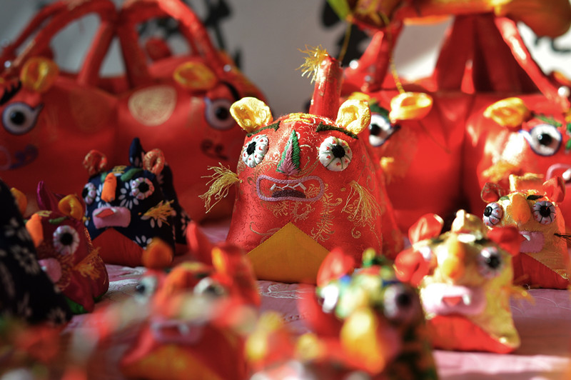 2022年1月，在山東省青島市城陽區河套街道，民間手藝人趙建美為春節趕制手工布老虎鋪滿床面。 王海濱攝