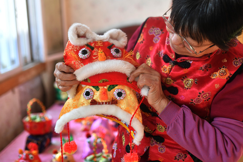 2022年1月，在山東省青島市城陽區河套街道，民間手藝人趙建美展示手工制作的民間傳統“虎頭帽”。 王海濱攝