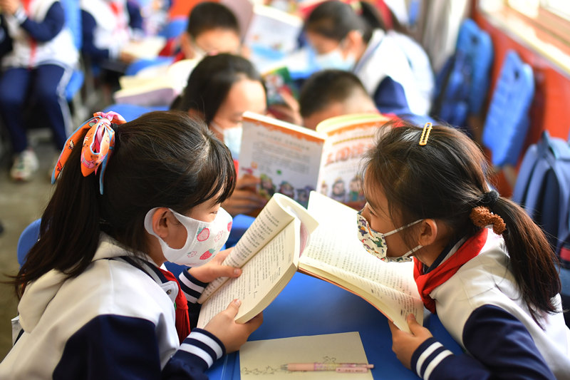 2022年4月20日，在山東省青島市重慶路第二小學舉行的“古典文學校園讀書節”活動上，學生們在閱讀古典文學《四大名著》。 王海濱攝