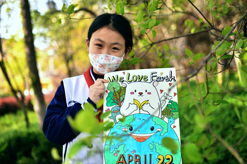2022年4月21日，在山東省青島市市北實驗小學開展的迎接“世界地球日”主題活動上，一名學生展示世界地球日主題畫作。 王海濱攝