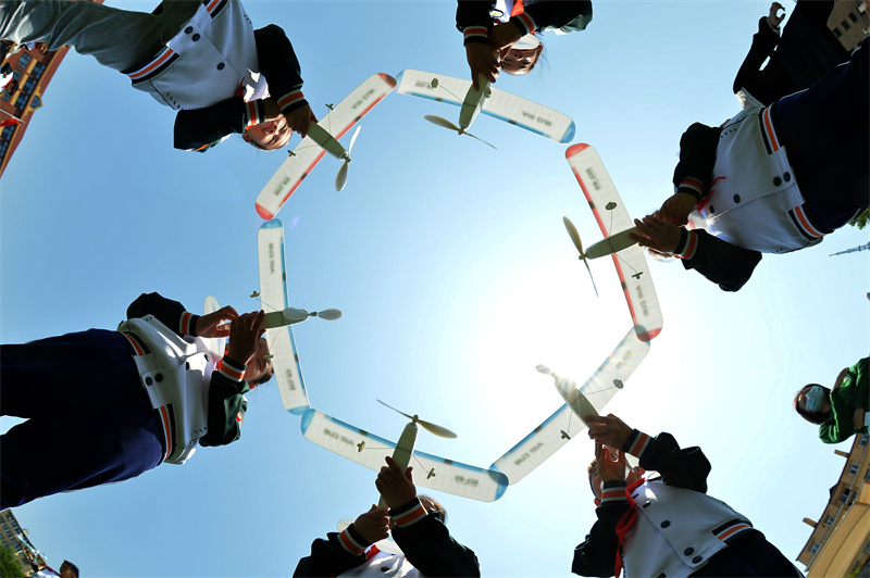 2022年5月18日，在山東省青島市延安二路小學開展的“校園科普周”活動上，學生們用橡筋動力飛機擺出造型，放飛夢想。 王海濱攝