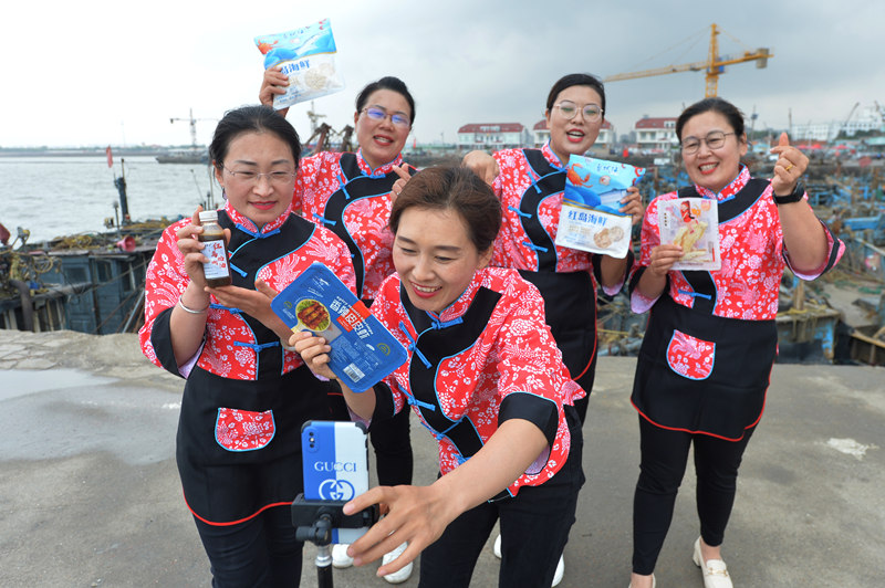 2022年6月13日，在山東省青島市城陽區紅島街道觀濤社區建立的網絡直播平台上，漁家“網紅”在碼頭上直播銷售海鮮。 王海濱攝