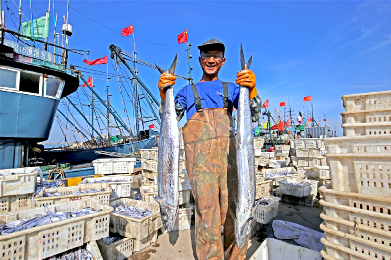 一位渔民正在展示捕获的大鲅鱼。薄林 摄