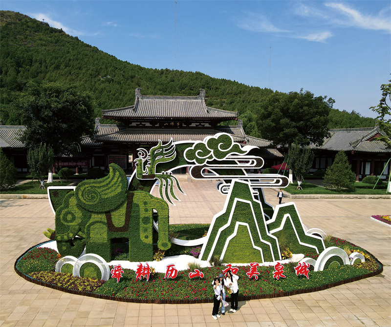 濟南千佛山公園景區裝扮一新，喜迎國慶。市民游客在花壇造型前合影留念。馬劍攝