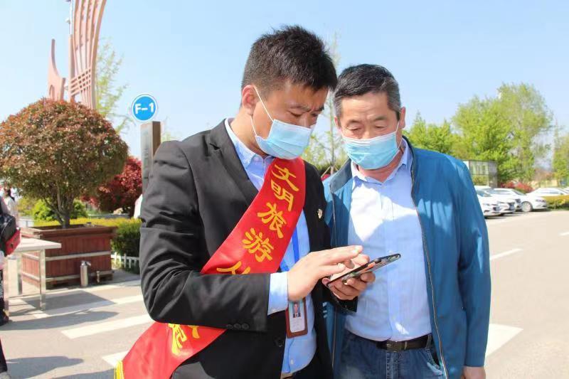 五一期间崂山风景区文明旅游志愿者为游客预约进山信息