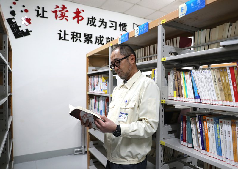 12月8日，日本专家小辻啓一在青岛松下电子部品（保税区）有限公司的书屋里查阅资料。张进刚摄