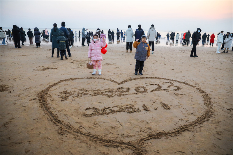 孩子在沙灘上寫下新年願望。李大偉攝