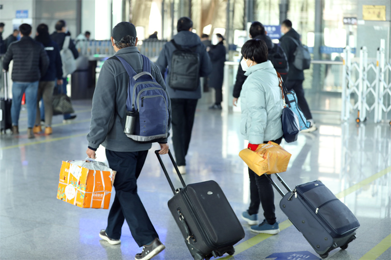 1月6日，在日照西客站，来来往往的旅客逐渐增多，不少外出务工人员扛着行李踏上回家路。宋年升摄 　