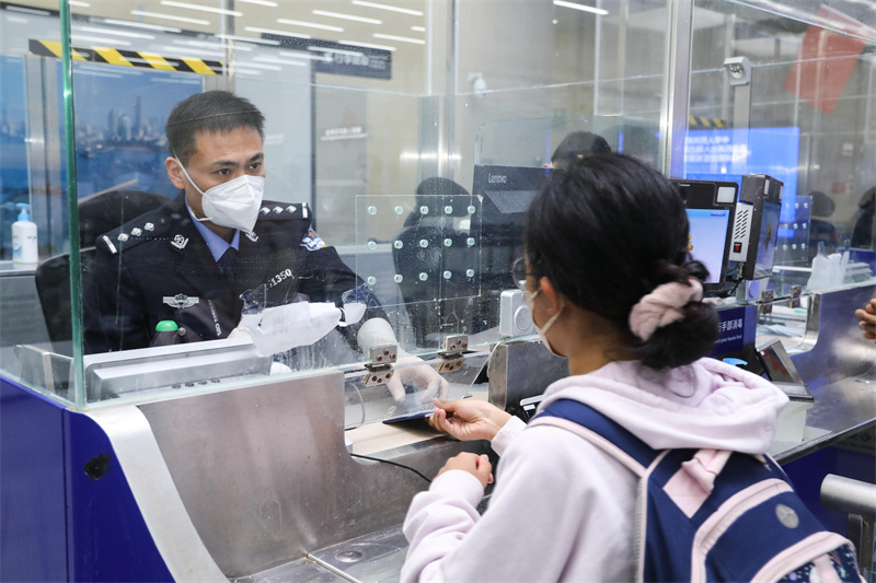 1月9日，山东出入境边防检查总站青岛机场边检站民警为入境旅客办理通关手续。解豪摄