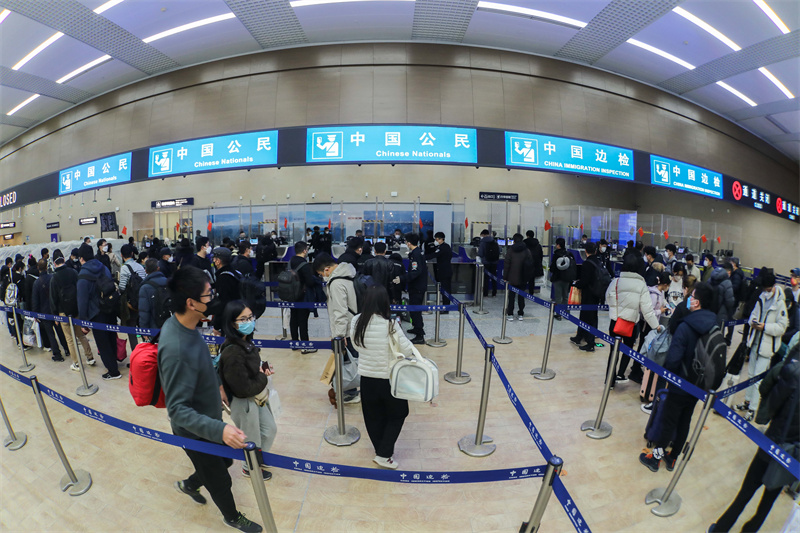 1月9日，山东出入境边防检查总站青岛机场边检站民警为入境旅客办理通关手续。解豪摄