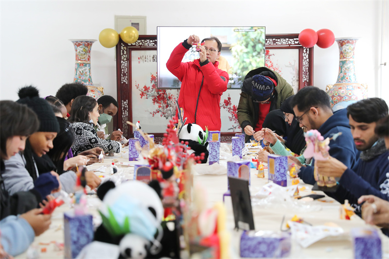 1月19日，民間藝人在山東科技大學教外國留學生制作絹人工藝品。張進剛攝