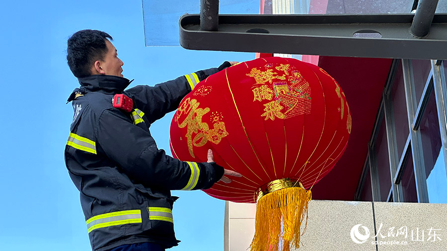 盛福庄消防救援站消防指戰員把燈籠高高挂起。喬姝攝