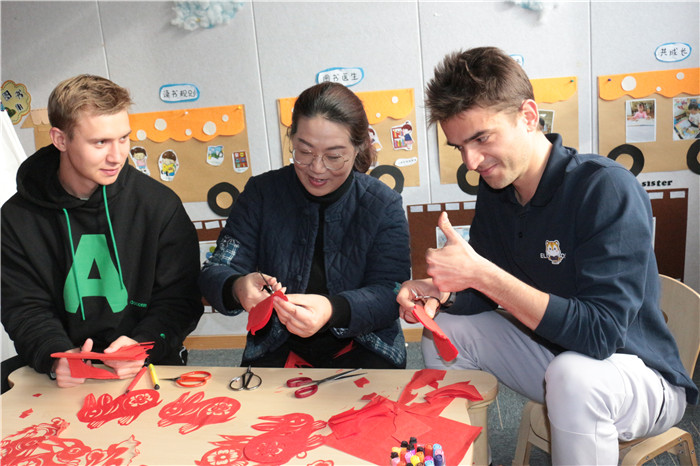 刘飞正在指导外国友人剪制瑞兔送财。邢葆东 摄