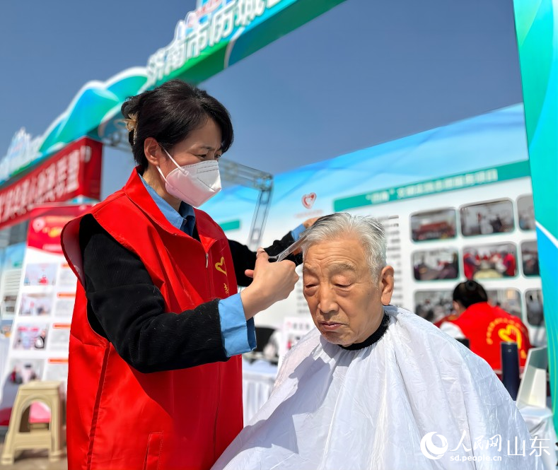 濟南市歷城區“四角”文明實踐志願服務項目的志願服務人員正在“理發角”為市民免費理發。人民網 喬姝攝