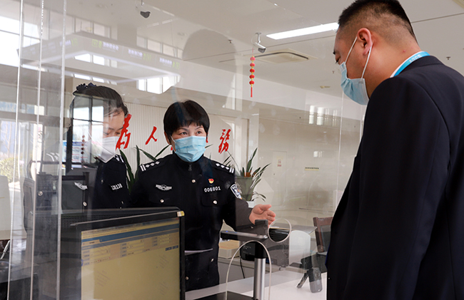 付俊红在车管大厅窗口指导业务办理。李悦摄