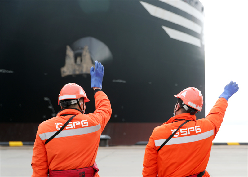 3月23日，碼頭工人在跟“地中海伊琳娜”號集裝箱貨輪揮手道別。張進剛攝