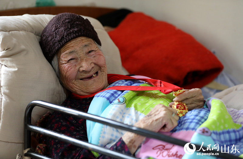 闫振仁老人抚摸着“光荣在党50年”纪念章。人民网 刘祺摄