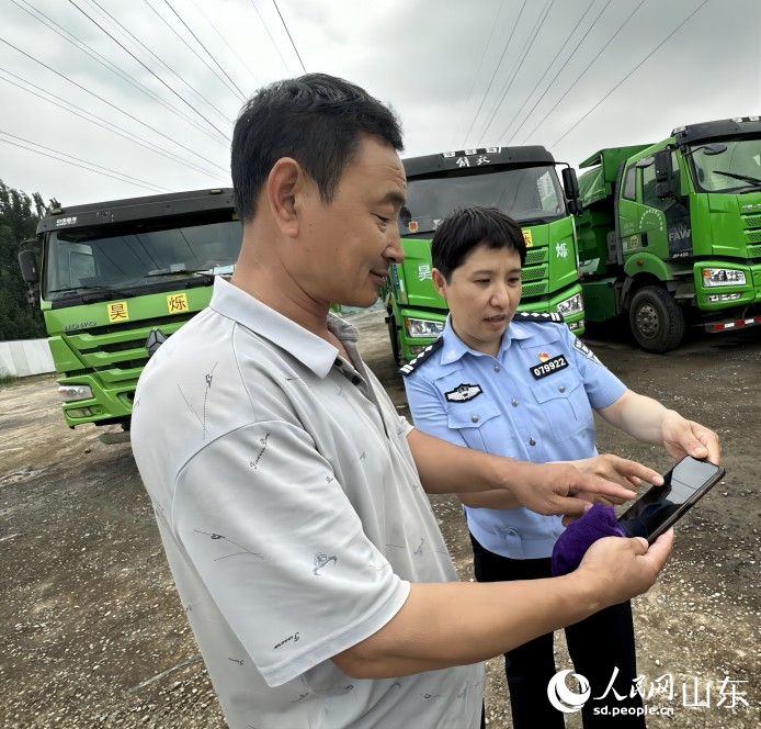 圖片3：德州市公安交警支隊民警為昊爍公司駕駛員講解微信群裡的交通安全提醒內容。人民網 喬姝攝