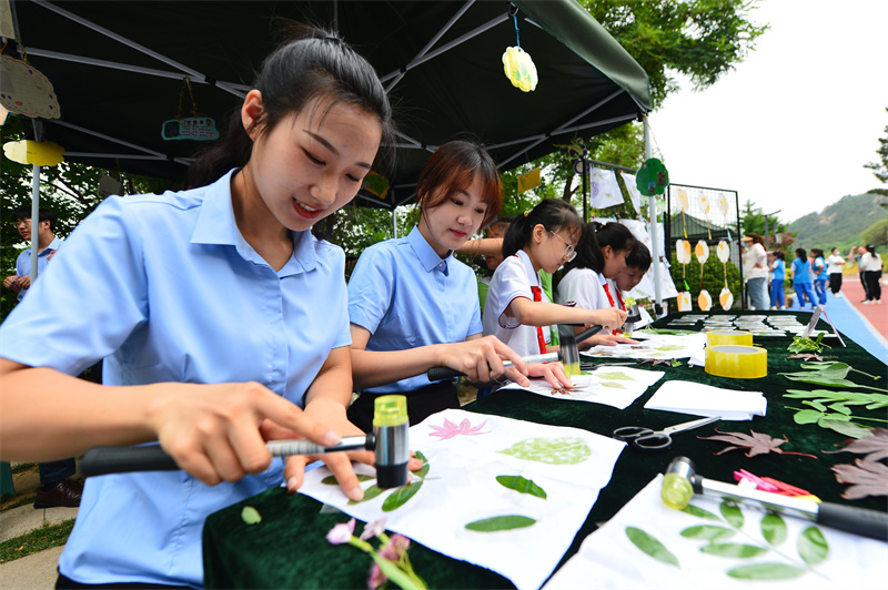 6月17日，在山東省青島市城陽區夏庄街道丹山森林公園，丹山小學的師生在制作樹葉拓印畫。王海濱攝