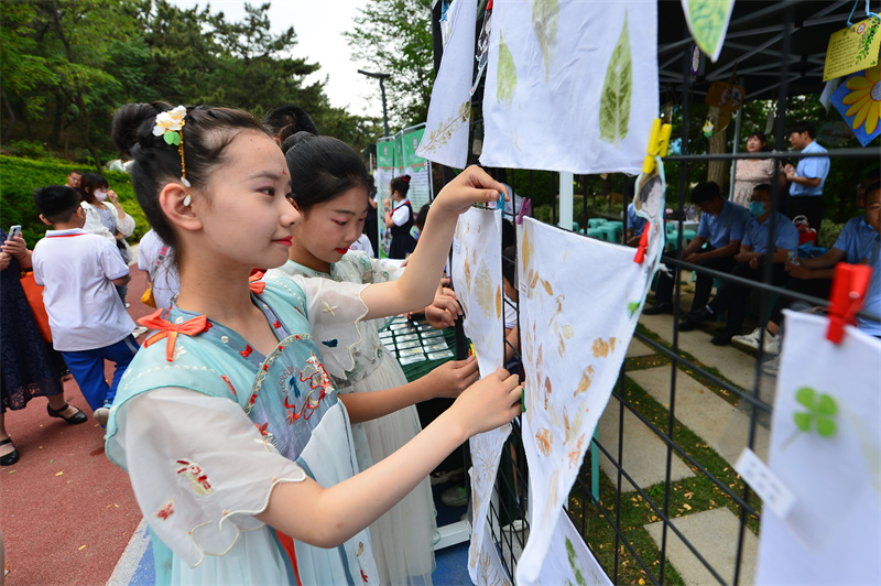 两名丹山小学的学生在摆放树叶拓印画。王海滨摄