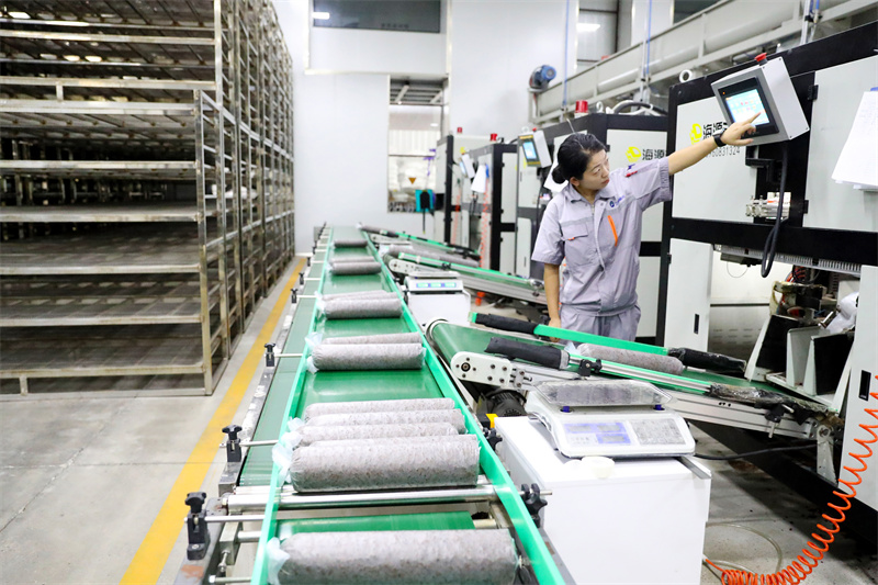 8月13日，在山东莱西市一家菌菇培育加工企业的菌棒生产线上，工作人员在对设备的参数进行检查。张进刚摄