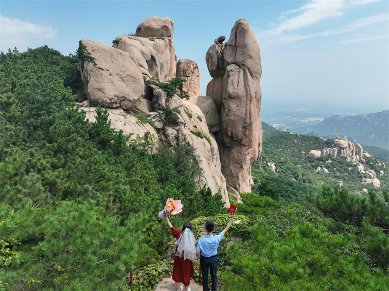 情侶在情侶峰前比心拍照，許下心願，在九仙山的見証下，此生此世唯此一人。陳鵬飛攝