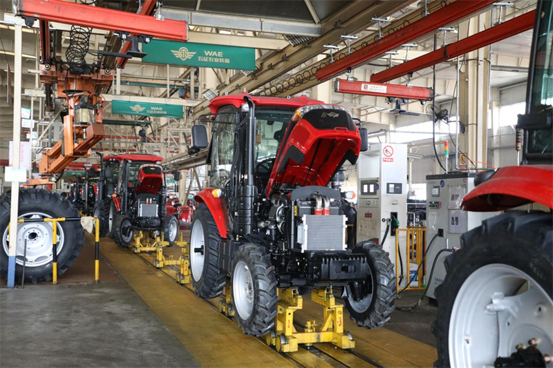 山东五征集团有限公司工人在车间组装生产大型农机设备，现场一片繁忙。王涛摄
