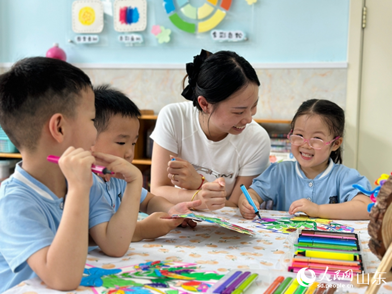 教师节前夕，在济南市市中区乐山幼儿园，老师正在指导孩子们给绘画作品涂色。人民网 乔姝摄