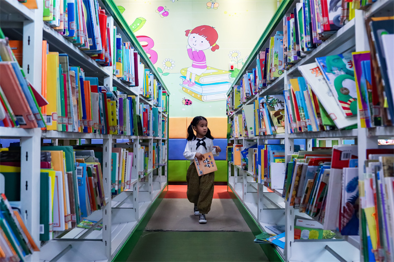 在山東省日照市圖書館內，一名小朋友正在挑選自己喜歡的書籍。張明慷攝