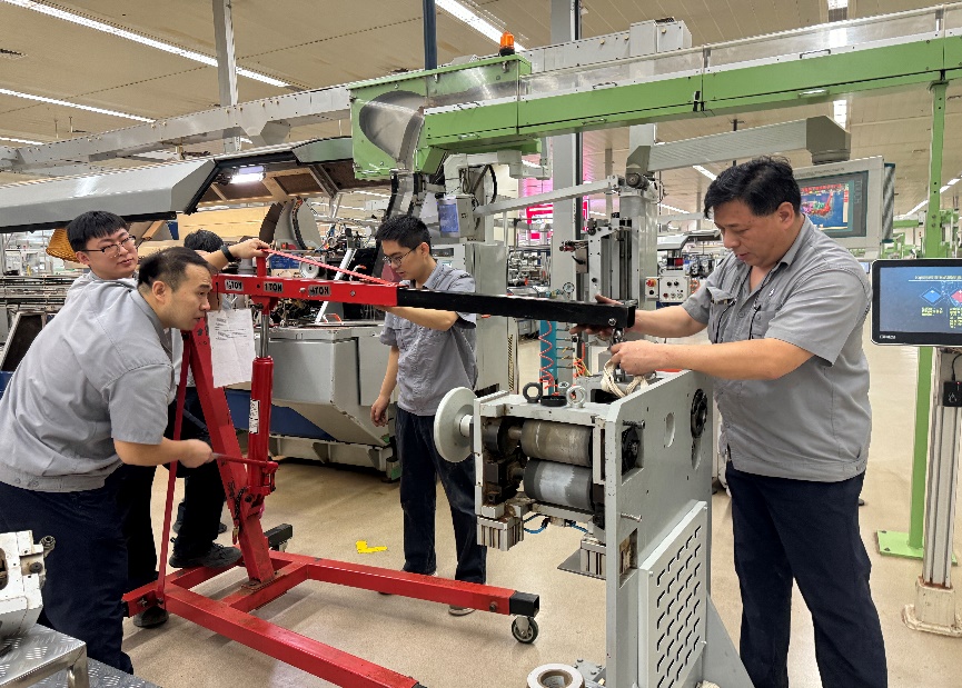 济南卷烟厂包装机维修工在更换铝箔纸切割辊轮总成。