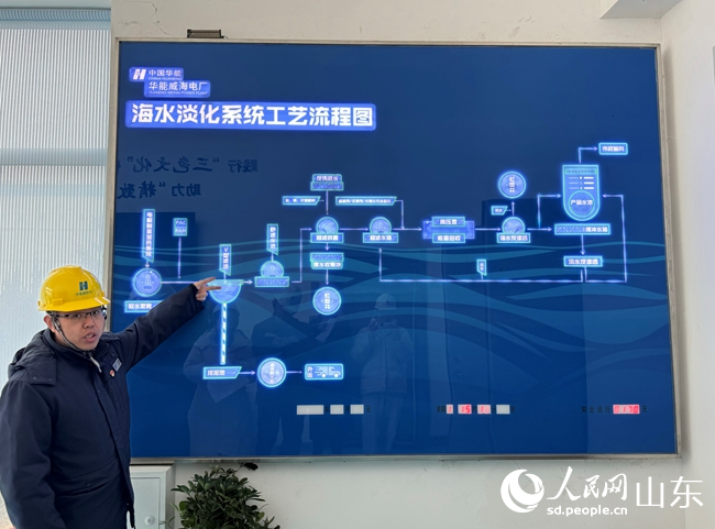 華能威海電廠運營部主任助理王子闖正在講解海水淡化工藝流程。人民網周素錦攝。