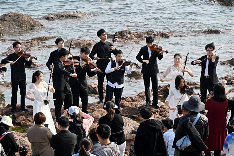 4月18日，中国海洋大学美育通识课学生及艺术系学生在青岛市市南区栈桥景区演奏。