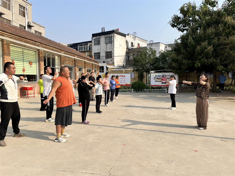 圖為李彤帶領憨兜家園的孩子們做早操