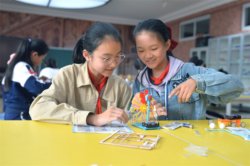 2024年10月10日，在山東青島普新小學的手工課堂上，兩名學生在安裝制作泡泡機。