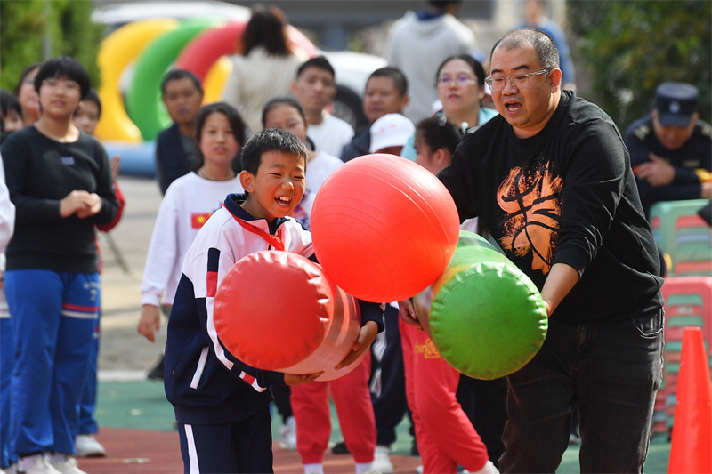 運動會上，孩子們在參加“夾球跑”親子趣味運動比賽。王海濱攝