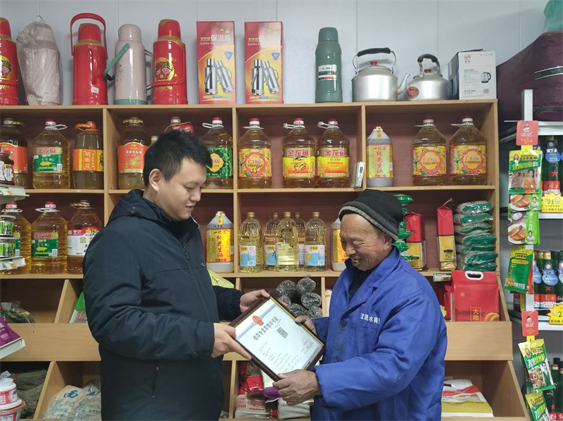 图为齐河烟草稽查员为老年零售客户提供“送证上门”服务