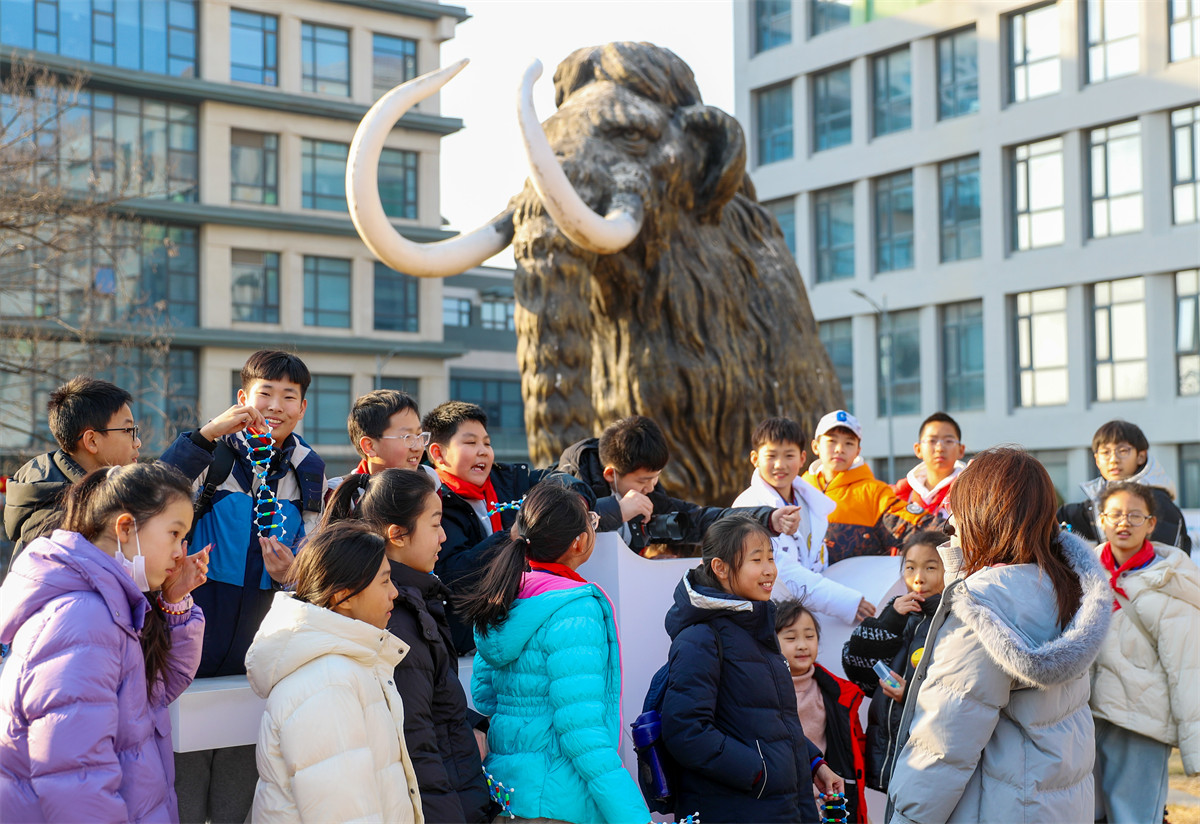 2月10日，在青島華大基因研究院，青島大學路小學六年級四班的同學在聽科研人員講解科學家們“復活”猛犸象的最新進展。（張進剛攝）