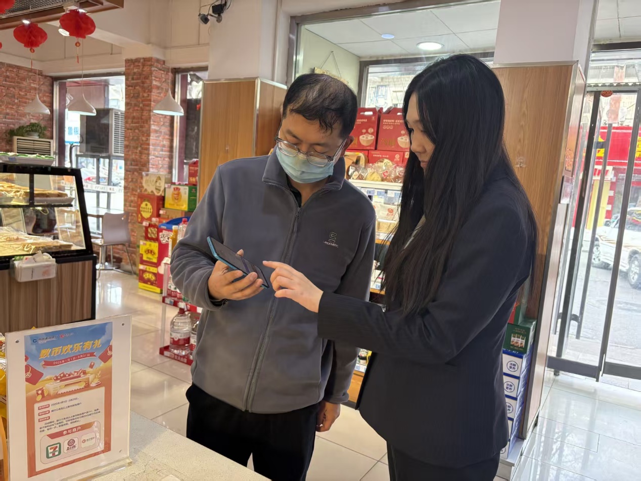 山东济南分行客户经理前往益康门店，为前来购买元宵的顾客详细介绍数币优惠。