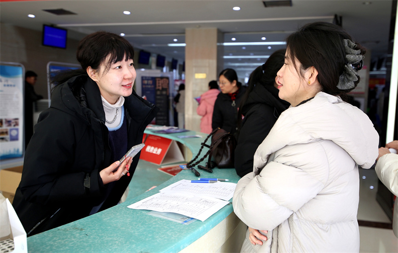 在临沂市人力资源市场，企业工作人员正向求职者介绍企业情况。