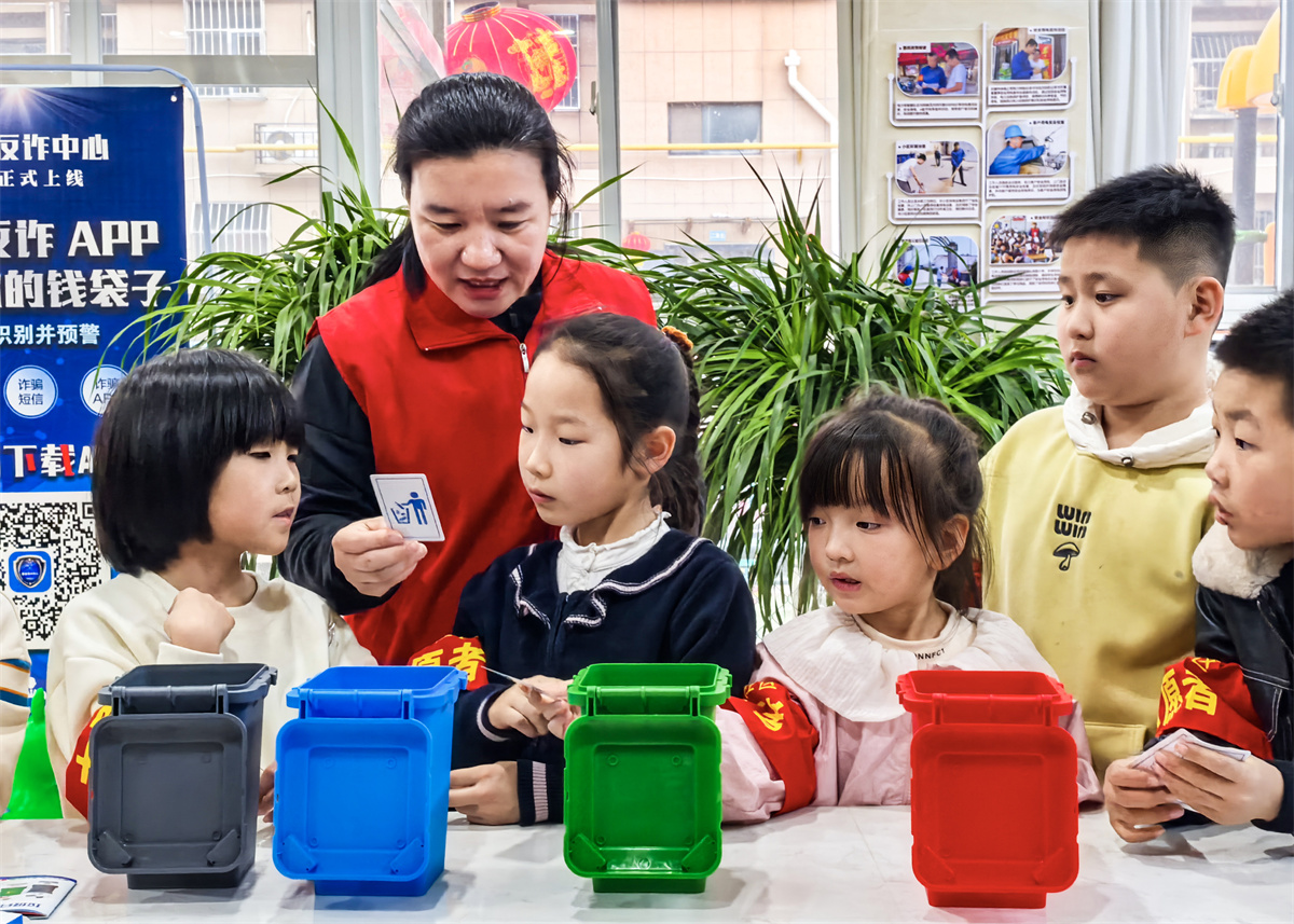 2025年3月1日，志愿者在山东省乐陵市“学雷锋·文明实践我行动”幸福市集现场向孩子们宣传垃圾分类知识。