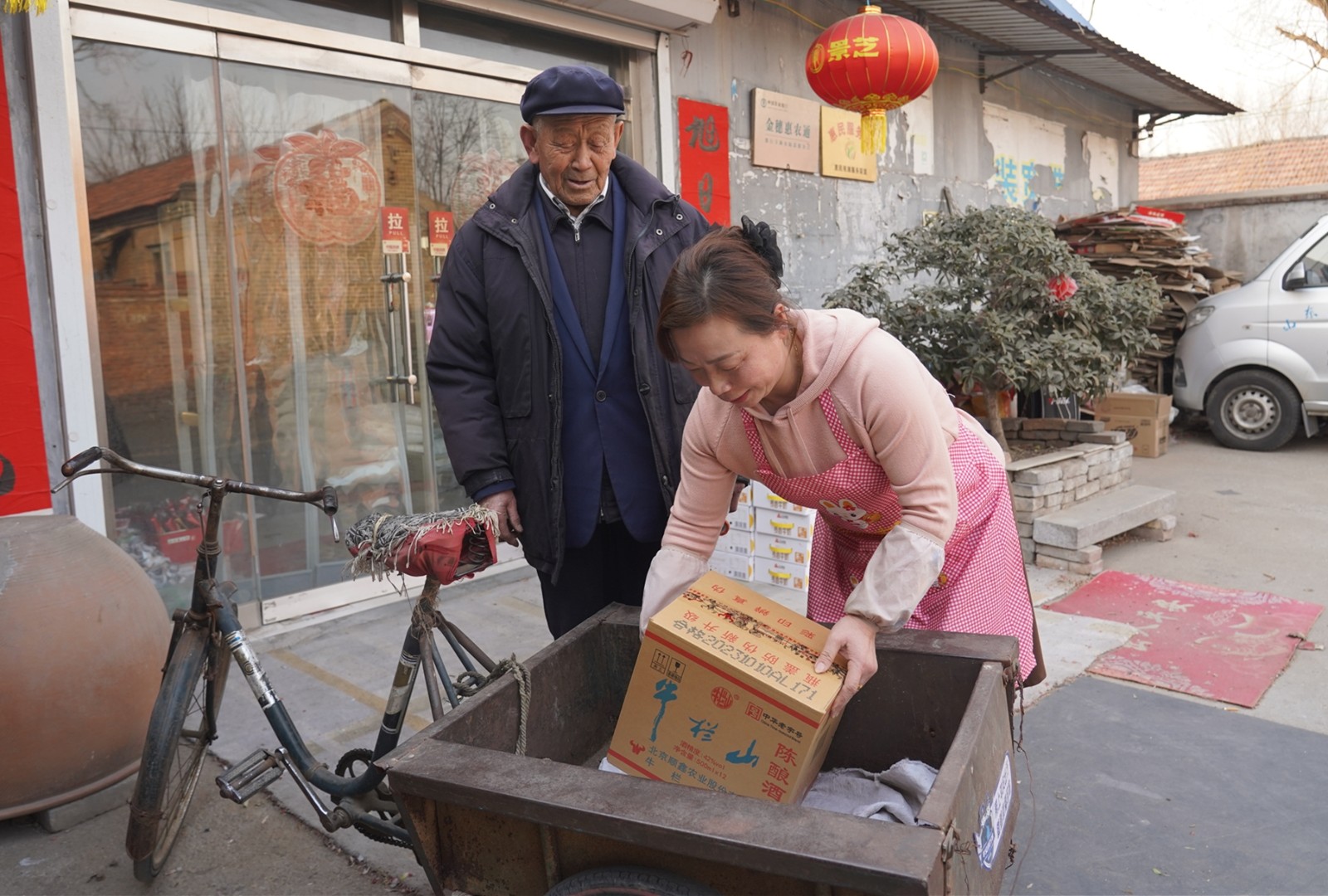 圖為陳蕾（右）幫前來購物的老人搬運貨物